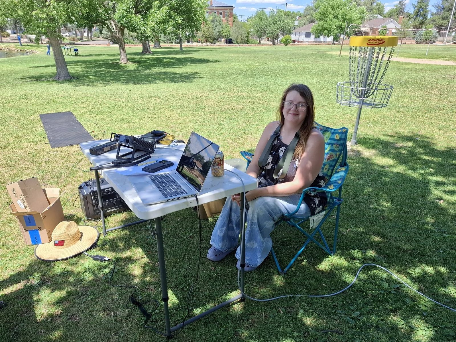 Member operating from a folding table out on the park grass.